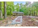 Landscaped front yard with decorative stone and mulch pathways lead to a charming home nestled among lush trees at 2633 Jonesboro Rd, Fairburn, GA 30213