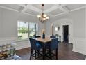 Dining area with a view showcasing a coffered ceiling, modern chandelier, marble table, and stylish decor at 524 Trousseau Ln, Mcdonough, GA 30252