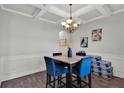Elegant dining area with coffered ceilings, stylish chandelier, and seating for four at 524 Trousseau Ln, Mcdonough, GA 30252