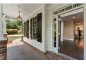 Covered porch with brick flooring, leading to the front door and a glimpse of the interior at 550 Vinings Springs Se Dr, Mableton, GA 30126