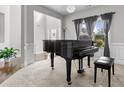 Elegant living room featuring a grand piano, complemented by large windows and stylish decor at 6062 Fielder Way, Douglasville, GA 30135