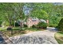 Brick home surrounded by trees and a well-manicured lawn at 415 Oak Laurel Ct, Johns Creek, GA 30022