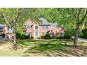Charming brick home featuring lush greenery and a well-maintained front lawn at 415 Oak Laurel Ct, Johns Creek, GA 30022