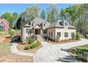 Stunning brick home with professional landscaping, arched windows, and a circular driveway at 6050 Eagle Close Ln, Sugar Hill, GA 30518