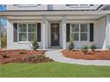 Inviting entrance to a home with a well-manicured lawn and elegant white columns at 6680 Benchwood Path, Cumming, GA 30028