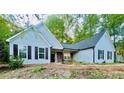 Attractive single-story home featuring light blue siding, black shutters, and a stone porch at 7675 Lanier View Rdg, Cumming, GA 30041