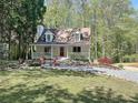 Charming two-story home with a landscaped yard, welcoming front porch and fire pit sitting area at 1004 Westminister Ct, Woodstock, GA 30188