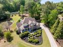 Aerial view of a brick home with manicured lawn and established greenery in a desirable neighborhood at 202 Carrington Estates Ct, Woodstock, GA 30188
