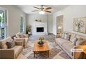 Bright, staged living room features neutral tones, a fireplace, and a ceiling fan at 2390 Century Ln, Snellville, GA 30039