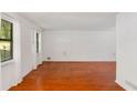 Bright living room featuring wood floors, large windows with sheer curtains, and freshly painted white walls at 484 Aberdeen Dr, Stonecrest, GA 30083