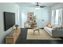 Cozy living room featuring a ceiling fan, hardwood floors, and large windows for ample natural light at 110 Ridge Se Ct, Mableton, GA 30126