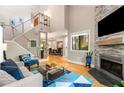 Open living room features a fireplace, hardwood floors, a modern staircase, and large windows for natural light and a view at 2002 Cedar Chase Ne Ln, Atlanta, GA 30324
