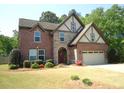 Charming two-story brick home with stone accents, a two-car garage, and a well-manicured front lawn at 3215 Trowbridge Dr, Cumming, GA 30040