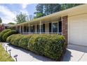 Close up view of the front of a one-story brick home with a covered front porch and manicured bushes at 4350 Bonaparte Dr, Tucker, GA 30084