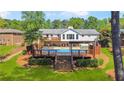 Expansive backyard featuring a pool, wooden deck, patio area, and mature trees at 1834 Kimberly Sw Dr, Marietta, GA 30008