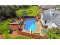 Aerial view of a private backyard featuring a sparkling pool, deck, and lush landscaping at 1834 Kimberly Sw Dr, Marietta, GA 30008