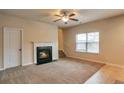 Cozy living room featuring a fireplace, plush carpet, and a bright window, perfect for relaxing or entertaining guests at 2513 Shropshire Pl, Mcdonough, GA 30253