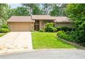 Charming single-Gathering home featuring an attached garage, lush landscaping, and stone accents at 4030 Muirfield Ln, Marietta, GA 30068