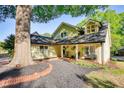 Charming home featuring a brick walkway, mature trees, a front porch with seating, and an attached garage at 4157 Town Branch Ct Sw, Covington, GA 30014