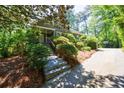 Serene view of the home's exterior, featuring a stone stairway and mature landscaping, adding to its curb appeal at 728 Wesley Nw Dr, Atlanta, GA 30305