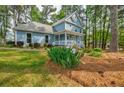 Well-maintained lawn and landscaping surround this charming two-story home with light blue siding at 1697 Ramblewood Way, Snellville, GA 30078