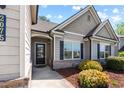 Home's inviting entrance features a well-lit door and manicured landscaping at 2075 Villa Spring Ct, Dacula, GA 30019