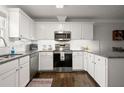 Modern kitchen featuring white cabinets, stainless steel appliances, granite countertops, and hardwood floors at 3065 Camden Way, Alpharetta, GA 30005