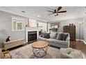 Cozy living room with a gray sofa, decorative pillows, fireplace, ceiling fan, and a neutral color palette at 3065 Camden Way, Alpharetta, GA 30005