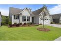 Inviting home with manicured lawn, landscaped garden bed, and an attached two car garage at 408 Cottonwood Cir, Peachtree City, GA 30269