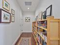 Inviting hallway featuring a wood bookshelf lined with books, hardwood floors, and curated artwork at 1820 Peachtree Nw St # 1008, Atlanta, GA 30309