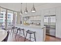Modern kitchen with stainless steel appliances, white cabinetry, and a kitchen island with stool seating at 1820 Peachtree Nw St # 1008, Atlanta, GA 30309