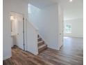 Bright foyer with wood-look flooring, staircase, and adjacent powder room at 2117 Boxwood Se Cir, Conyers, GA 30094