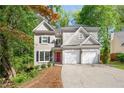 Inviting home featuring a red front door, black shutters, a two-car garage, and landscaped front yard at 3902 Concord Walk Se Dr, Smyrna, GA 30082