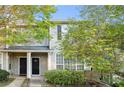 Inviting exterior of a townhouse featuring a well-maintained lawn and neutral color scheme at 241 Odyssey Turn Nw, Conyers, GA 30012