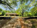 Residential home featuring a driveway and partial view of the property's spacious, green landscape at 5700 Abbotts Bridge Rd, Johns Creek, GA 30097