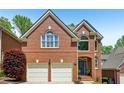 Beautiful brick home with a two-car garage, lush landscaping, and a welcoming entrance at 1228 Dunwoody Walk, Atlanta, GA 30338
