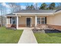 Inviting front entrance with well-manicured landscaping and a black front door at 217 Lamb Rd, Moreland, GA 30259