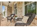 Cozy front porch showcases decorative brickwork and charming wicker seating at 10265 Grandview Sq, Johns Creek, GA 30097