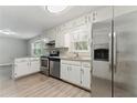 Functional kitchen featuring stainless steel appliances, white cabinets, granite countertops, and hardwood floors at 4716 Alpine Sw Dr, Lilburn, GA 30047