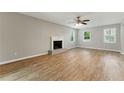 Bright living room featuring hardwood floors, a decorative fireplace, a ceiling fan and natural light streaming through multiple windows at 4716 Alpine Sw Dr, Lilburn, GA 30047