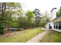 Serene backyard featuring a brick path, above ground pool, and mature trees for ultimate privacy at 794 Lucas Dr, Hampton, GA 30228