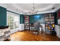 Inviting home office with beautiful hardwood floors, custom bookshelves, and ample natural light at 794 Lucas Dr, Hampton, GA 30228