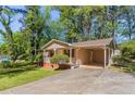 Single-story home boasts a covered carport and inviting front porch with lawn at 842 Brighton Dr, Lawrenceville, GA 30043