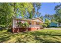 Side view of cozy single-story home with a front porch and well-maintained lawn at 842 Brighton Dr, Lawrenceville, GA 30043