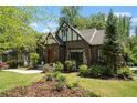 Charming Tudor-style home with a well-manicured lawn, beautiful landscaping, and classic architectural details at 937 E Rock Springs Ne Rd, Atlanta, GA 30306