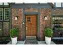 Inviting brick facade with a handsome wood door, decorative plants, and stylish sconces at 937 E Rock Springs Ne Rd, Atlanta, GA 30306