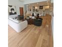 Open-concept living room and kitchen with wood floors, modern furniture, and white cabinets at 4450 Muhammad Dr, South Fulton, GA 30349