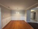 Traditional dining room with hardwood floors, wainscoting, and elegant chandelier at 1365 Jubilee Ln, Mcdonough, GA 30253