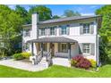 Charming two-story home with a well-manicured lawn, a covered front porch, and mature landscaping at 218 Midvale Ne Dr, Atlanta, GA 30342