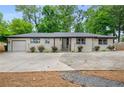 Inviting one-story home with painted brick, new driveway, and fresh landscaping for a clean, modern look at 3154 N Druid Hills Rd, Decatur, GA 30033
